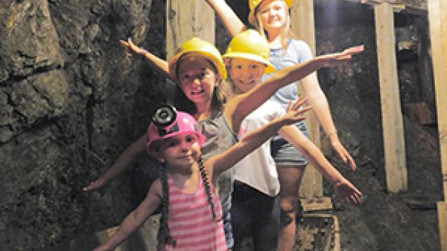 Kids posing in mine cart in tunnel on tour